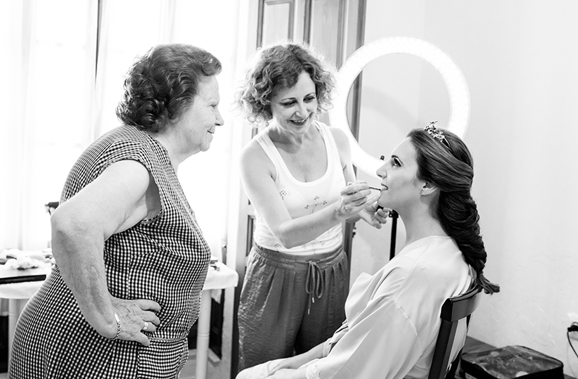 labio rojo para María bajo la atenta mirada de su madre